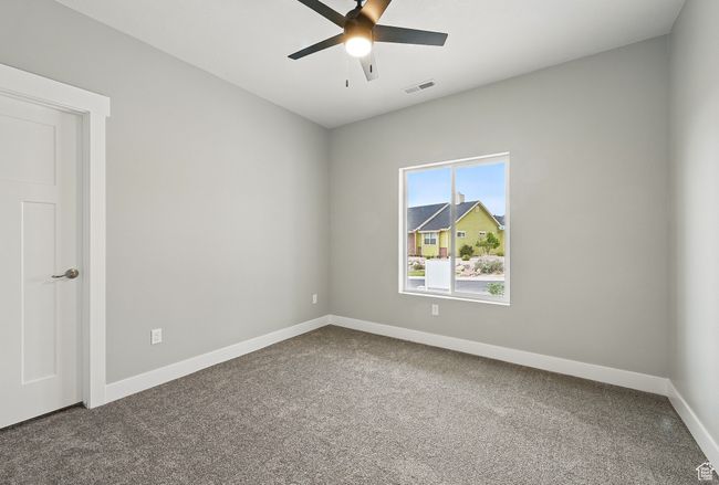 Unfurnished room with dark carpet, baseboards, and a ceiling fan | Image 43
