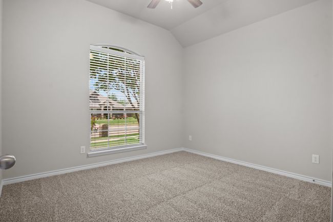 Unfurnished room with carpet floors, ceiling fan, vaulted ceiling, and baseboards | Image 27