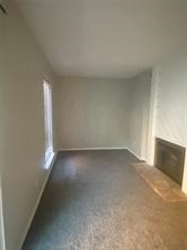 Unfurnished living room with a fireplace with raised hearth | Image 14