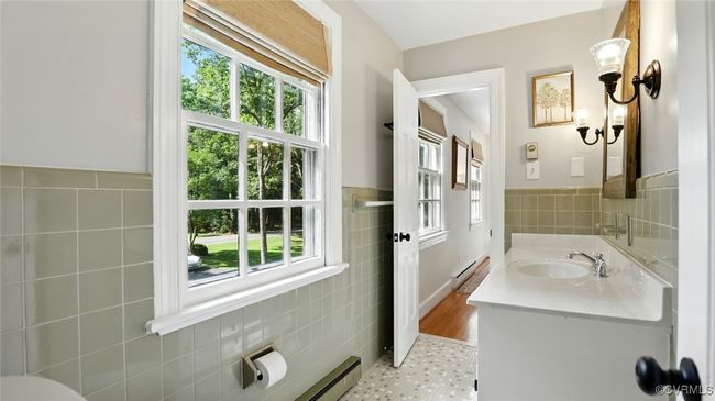 Bathroom featuring tile walls, healthy amount of natural light, vanity, wainscoting, and tile patterned floors | Image 26