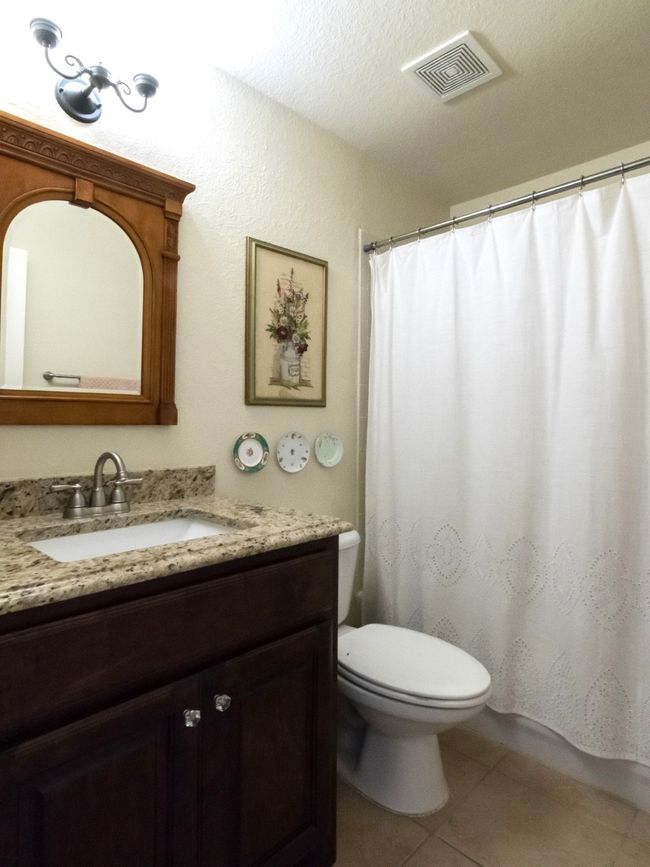 Secondary bathroom features tub/shower combination, framed mirror, and updated lighting and fixtures. | Image 30