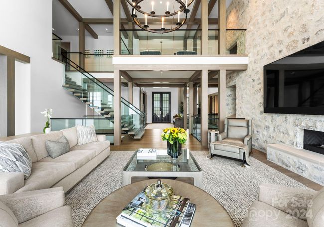 Highlighting the glass balustrade and grand entry doors in the foyer. | Image 6