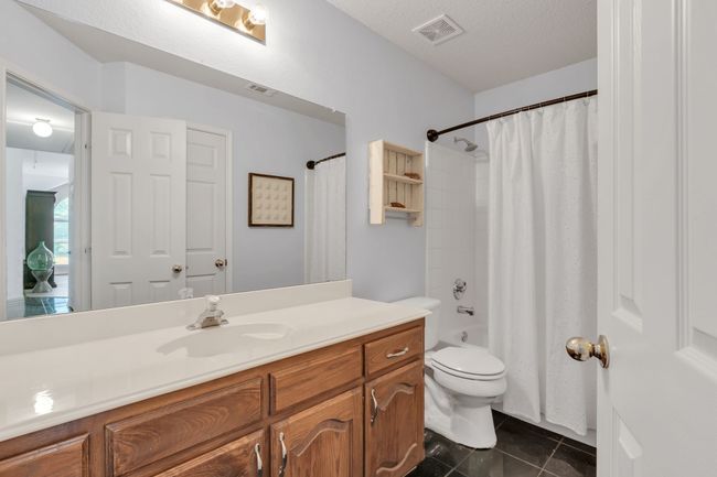 Full bath featuring tile patterned floors, visible vents, toilet, vanity, and a textured ceiling | Image 28