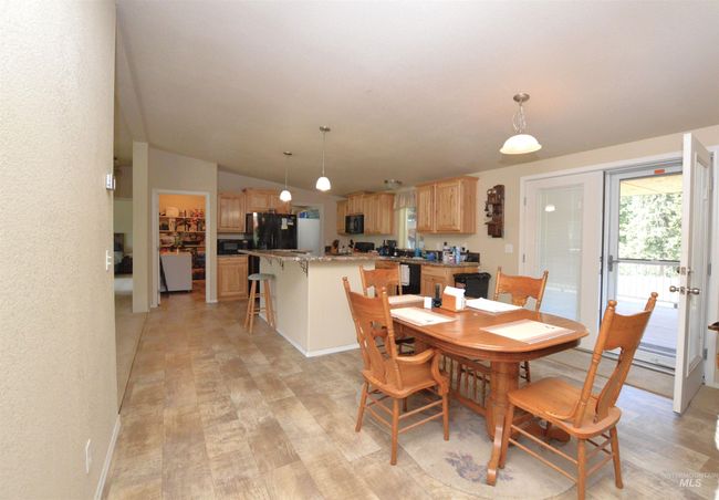 Dining area featuring light wood-style floors and lofted ceiling | Image 6