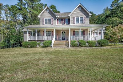 View of front facade featuring a porch and a front yard | Image 1