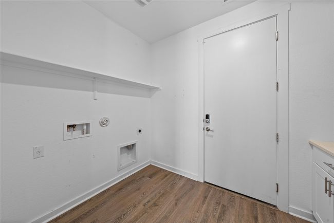 Washroom with washer hookup, wood finished floors, laundry area, and hookup for an electric dryer. Costume built ins | Image 18