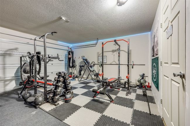 Exercise area featuring a textured ceiling | Image 31