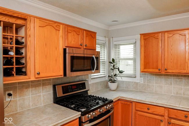 decorative backsplash, crown molding, and stainless steel appliances | Image 9