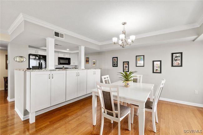 Dining room featuring a raised ceiling, visible vents, crown molding, and light wood-style floors | Image 7