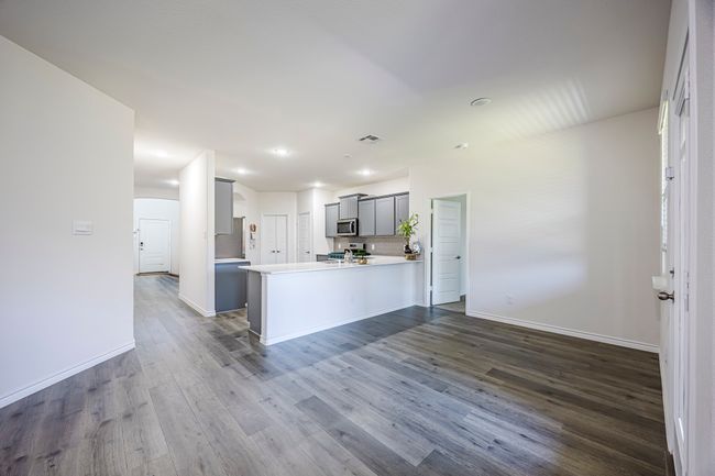 Kitchen featuring stainless steel microwave, dark wood finished floors, arched walkways, range, and light countertops | Image 10