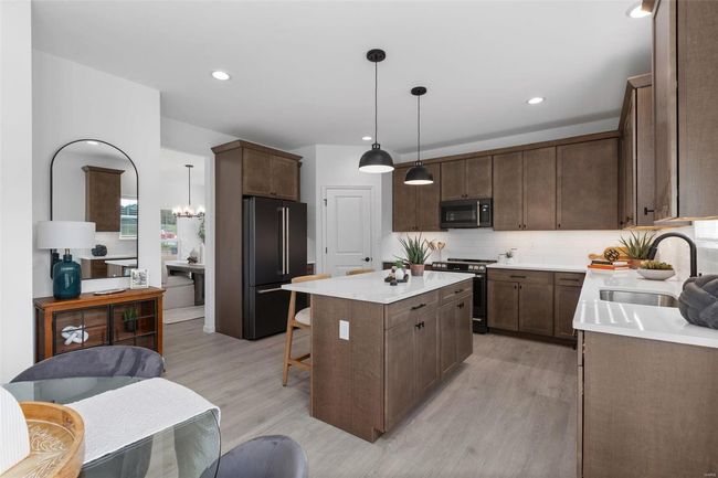 Kitchen with a kitchen island, pendant lighting, stainless steel appliances, light wood-type flooring, and sink | Image 13
