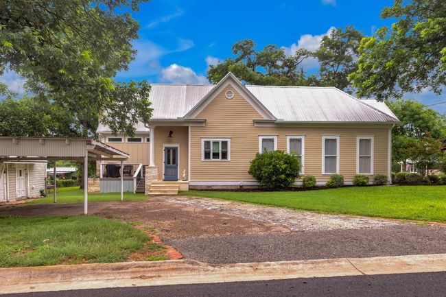 View of front facade featuring a metal roof, a front yard, and dirt driveway | Image 36