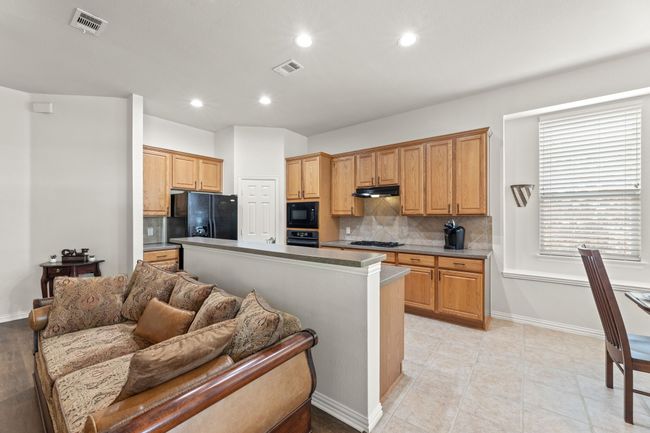 Kitchen featuring black appliances, backsplash, recessed lighting, under cabinet range hood, and baseboards | Image 17