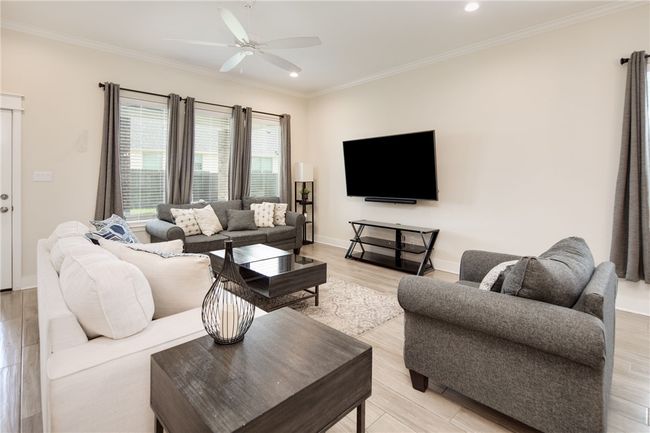 Living room featuring a ceiling fan, ornamental molding, recessed lighting, light wood finished floors, and baseboards | Image 4