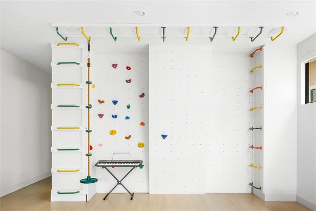 An indoor jungle gym adds a playful twist to the third floor—complete with a rock climbing wall, monkey bars, and rope swing. It’s the ultimate setup for climbing, creativity, and letting off steam, no matter the weather. | Image 30