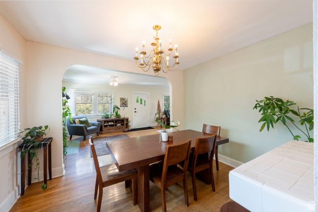 Dining area with arched walkways, light wood-style flooring, and a chandelier | Image 9