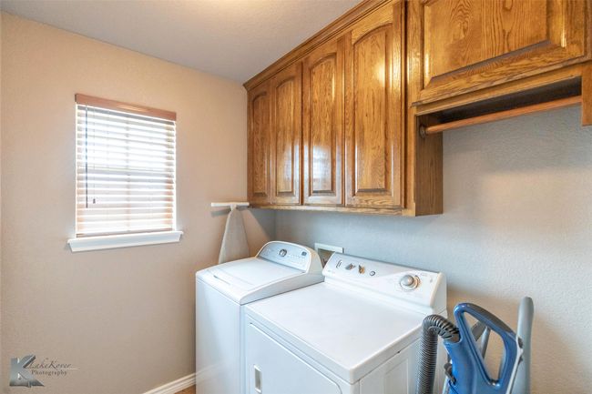 Washroom with washing machine and clothes dryer, cabinet space, and baseboards | Image 28