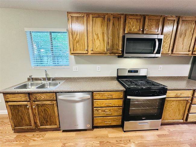 Kitchen with appliances with stainless steel finishes, light wood-style floors, and brown cabinets | Image 6