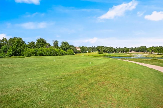 View of property's community featuring a water view, a yard, golf course view, and view of scattered trees | Image 17