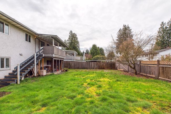 View of yard featuring stairs, a deck, and a fenced backyard | Image 37
