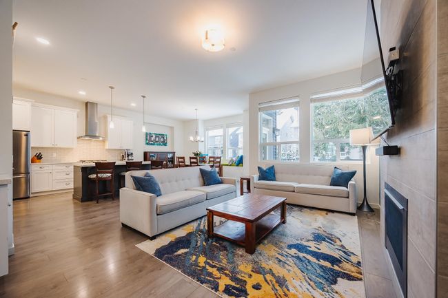 Living area with a fireplace, wood finished floors, and recessed lighting | Image 4