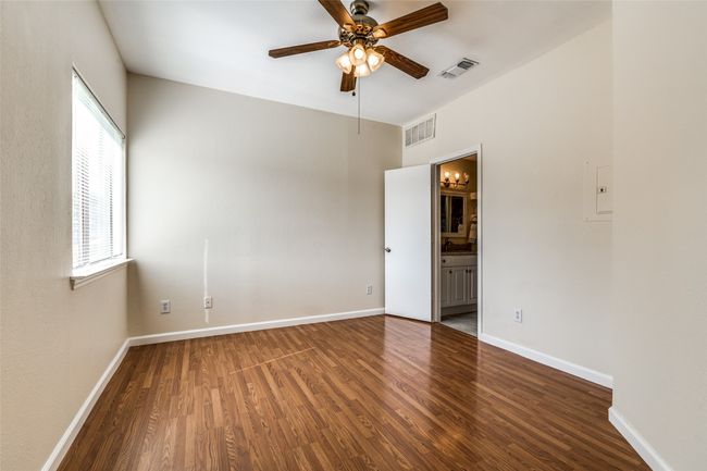Empty room featuring baseboards, visible vents, wood finished floors, and ceiling fan | Image 12
