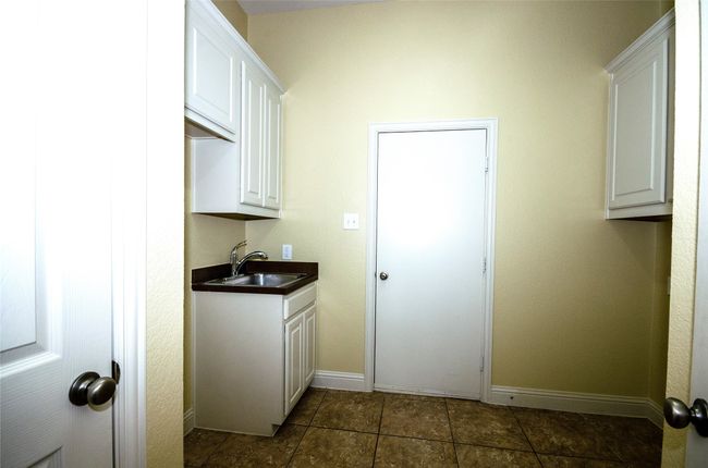 Laundry room featuring a sink and baseboards | Image 14