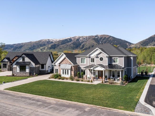 Craftsman inspired home featuring board and batten siding, a standing seam roof, a mountain view, covered porch, and stone siding | Image 46