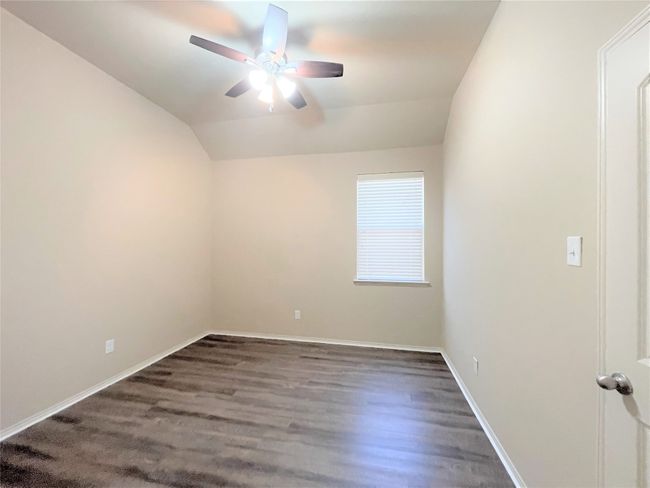 Spare room with ceiling fan, vaulted ceiling, and wood finished floors | Image 13