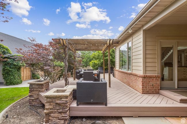 Deck featuring a pergola, outdoor dining area, and an outdoor living space with a fire pit | Image 75