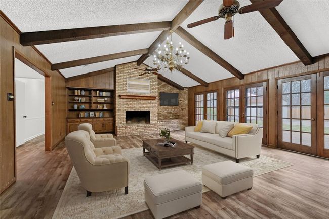Living area featuring a textured ceiling, a ceiling fan, wood finished floors, french doors, and wood walls ~ virtually staged | Image 4