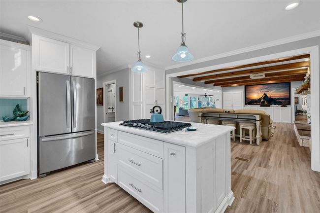 Kitchen featuring appliances with stainless steel finishes, ornamental molding, light wood-style floors, white cabinets, and recessed lighting | Image 16