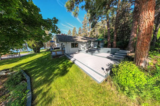 Rear view of property featuring a wooden deck and a yard | Image 53