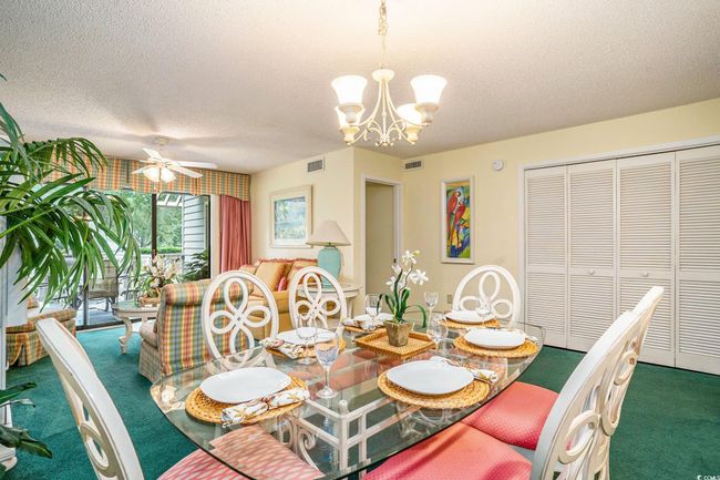 Dining room with a textured ceiling, carpet flooring, a chandelier, and ceiling fan | Image 7