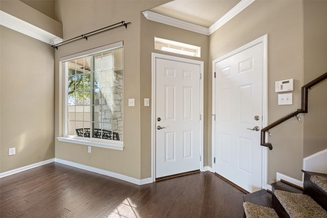 Entrance foyer with wood flooring, crown molding, and soaring ceilings bringing in natural light. | Image 8