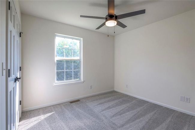 Carpeted spare room featuring a ceiling fan and baseboards | Image 16