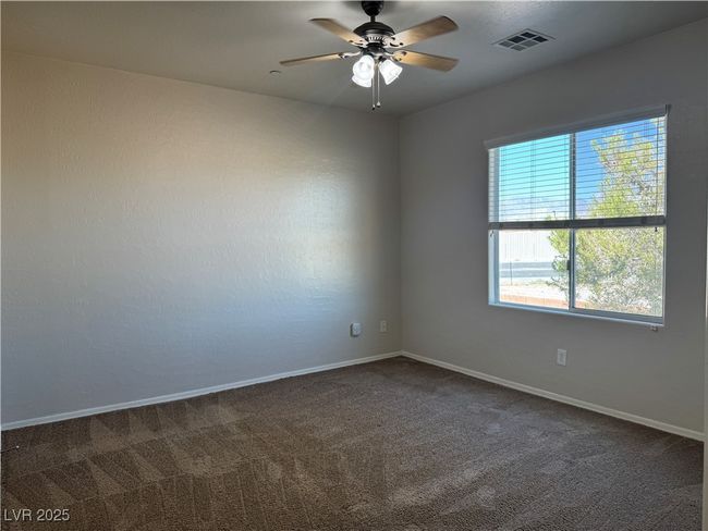 Unfurnished room with ceiling fan and dark colored carpet | Image 11