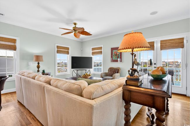Living area with ceiling fan, light wood-style flooring, and ornamental molding | Image 4