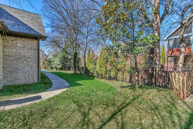 Your backyard is completely encompassed with a black metal fence to allow your family or pets to enjoy the outdoors. | Image 49