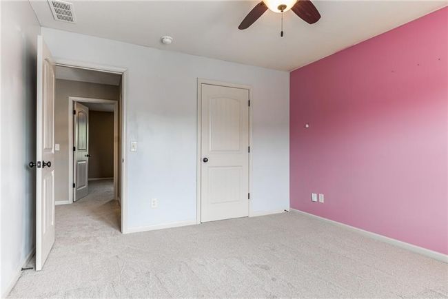 Unfurnished bedroom with light colored carpet and ceiling fan | Image 40