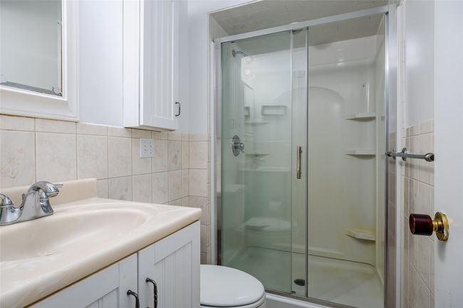 Bathroom featuring vanity, toilet, tile walls, and a shower stall | Image 31