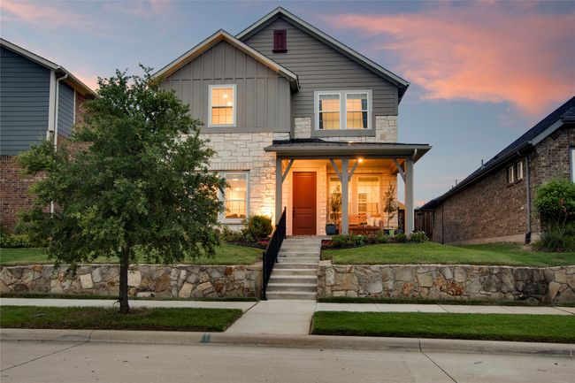 Traditional home featuring board and batten siding, stone siding, covered porch, and a yard | Image 33