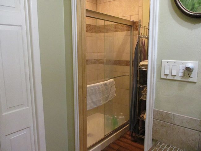 Bathroom featuring a shower with shower door and wood-type flooring | Image 26