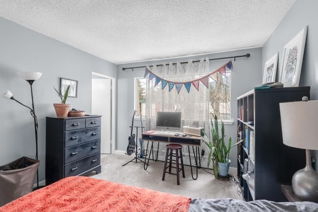 Bedroom featuring a textured ceiling, multiple windows, and carpet | Image 12