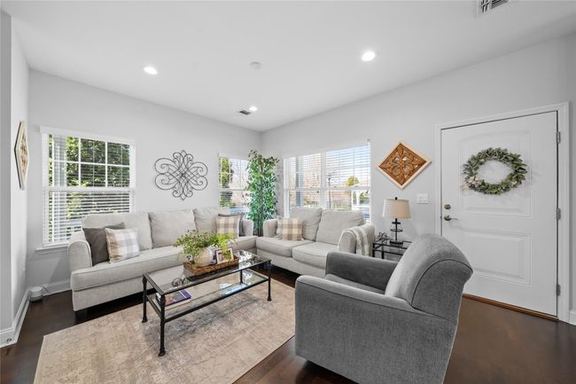 Living area featuring dark wood-style flooring, visible vents, and recessed lighting | Image 8