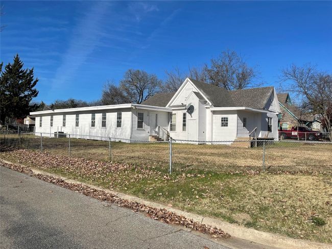 View of front of property featuring a fenced front yard, entry steps, and a shingled roof | Image 6