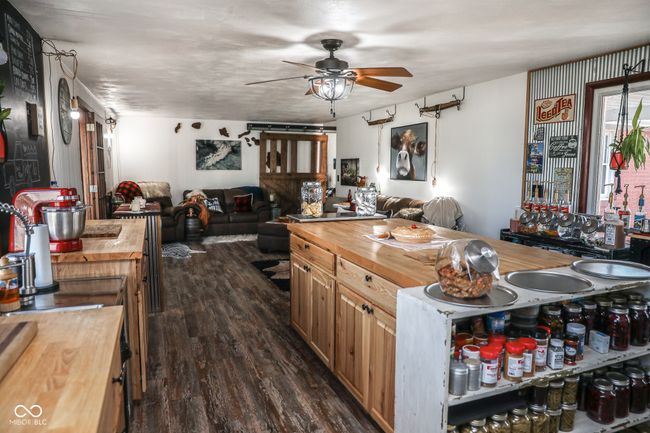 kitchen with a ceiling fan, open floor plan, dark wood-style flooring, and wood counters | Image 28