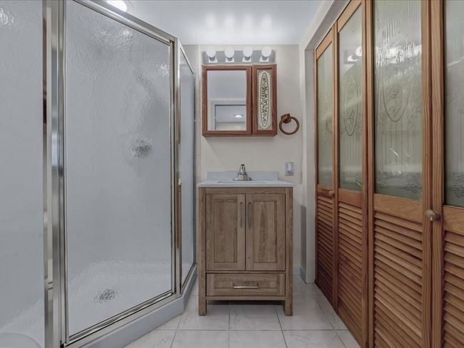 Bathroom with a shower stall, vanity, and tile patterned floors | Image 30
