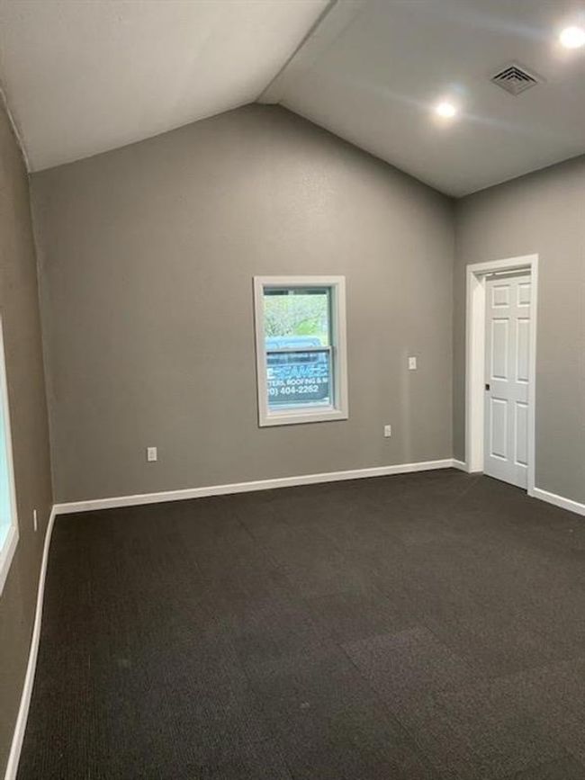 Carpeted empty room with lofted ceiling | Image 15