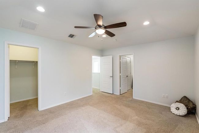 Unfurnished bedroom with a walk in closet, light colored carpet, recessed lighting, a closet, and ceiling fan | Image 10